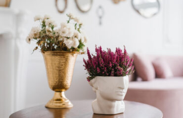 Decorative flower vases, one gold and one shaped like a head.