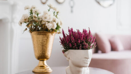 Decorative flower vases, one gold and one shaped like a head.