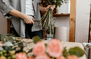 Florist arranging a bouquet of flowers indoors.