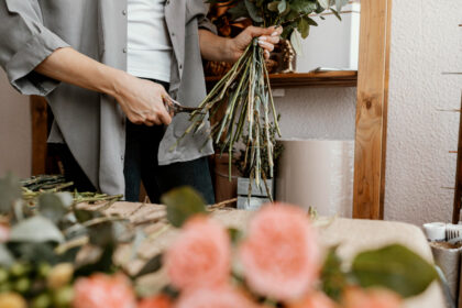 Florist arranging a bouquet of flowers indoors.