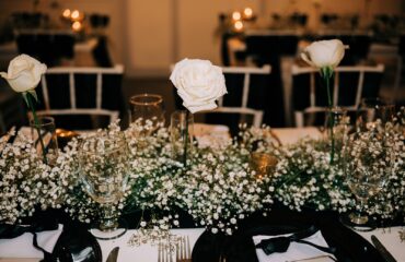 Elegant white floral centerpiece at a formal dining table.