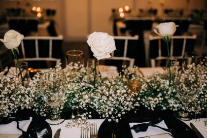 Elegant white floral centerpiece at a formal dining table.