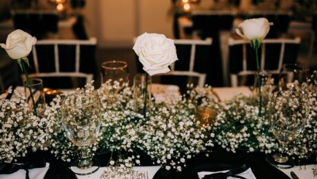 Elegant white floral centerpiece at a formal dining table.